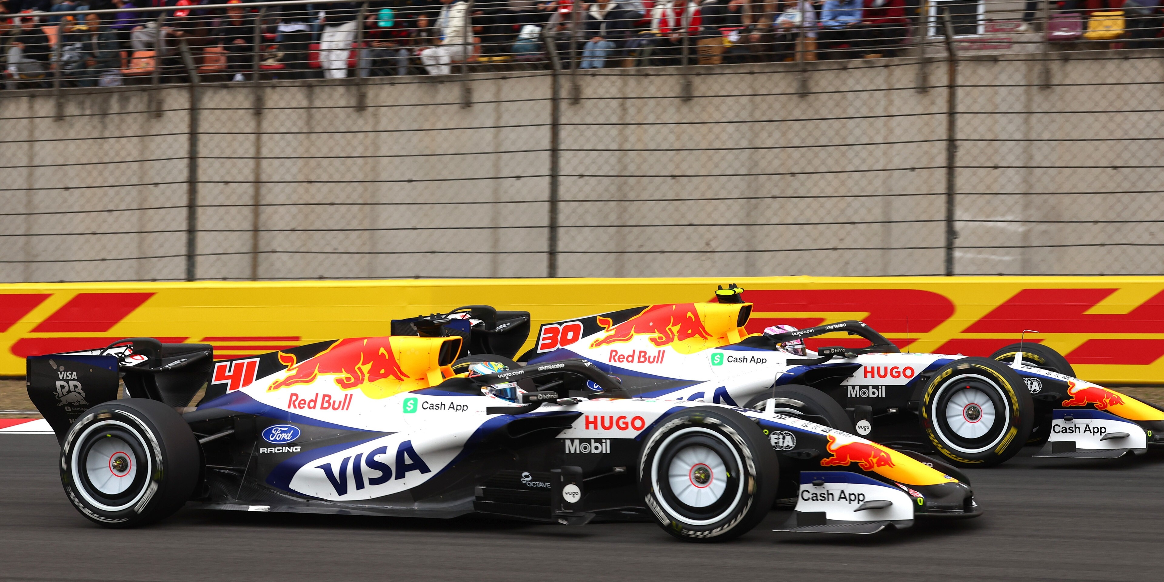 Liam Lawson of New Zealand driving the Visa Cash App Racing Bulls VCARB 03 RB Ford and Arvid Lindblad of Great Britain driving the Visa Cash App Racing Bulls VCARB 03 RB Ford battle for track position during the F1 Grand Prix of China at Shanghai International Circuit on March 15, 2026 in Shanghai, China.  PHOTO CREDIT: Red Bull Media House. 